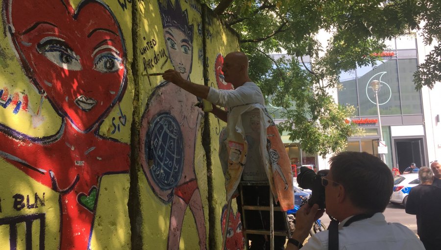 Artistas callejeros restauran las pinturas que hicieron en el Muro de Berlín en 1984